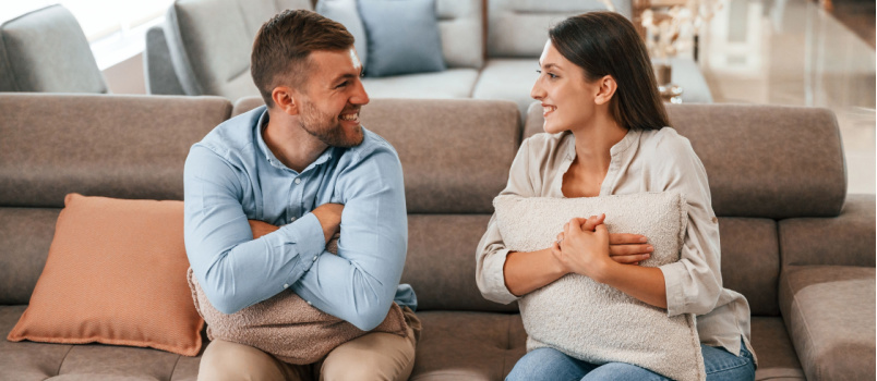 Happy couple sitting couch talking with each other