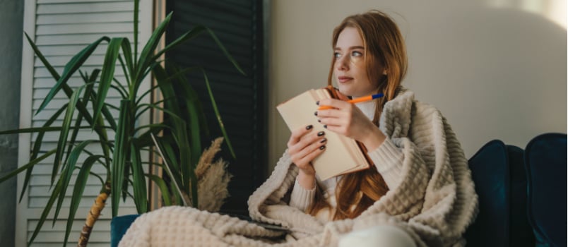 Woman sitting on sofa reading letter