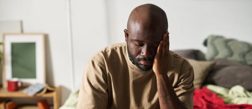 Angry man sitting on bed