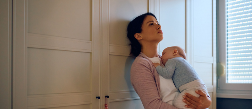 Mother thinking while holding baby