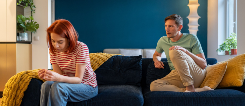 Young couple sitting on couch not communicating