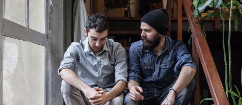 Young friends sitting on stairs talking to each other
