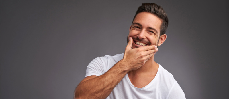 Handsome man touching his skin