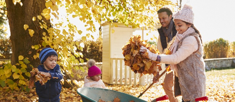 Children and father collecting autumn leaves