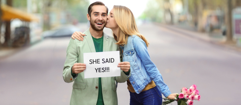 Young man holding paper she said yes
