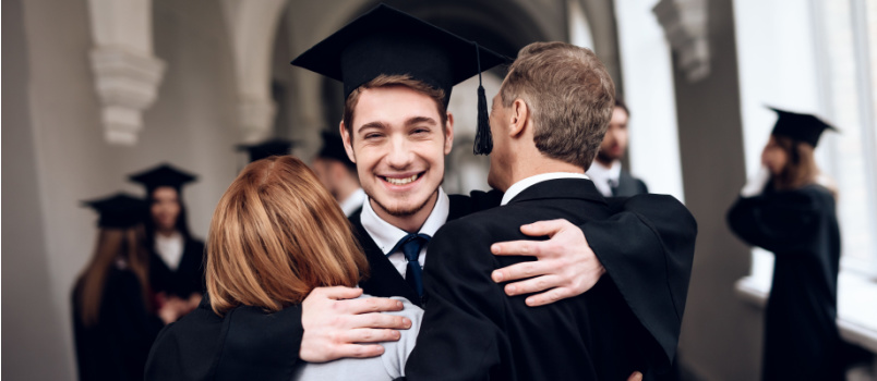 Guy hugging parents on clearing graduation