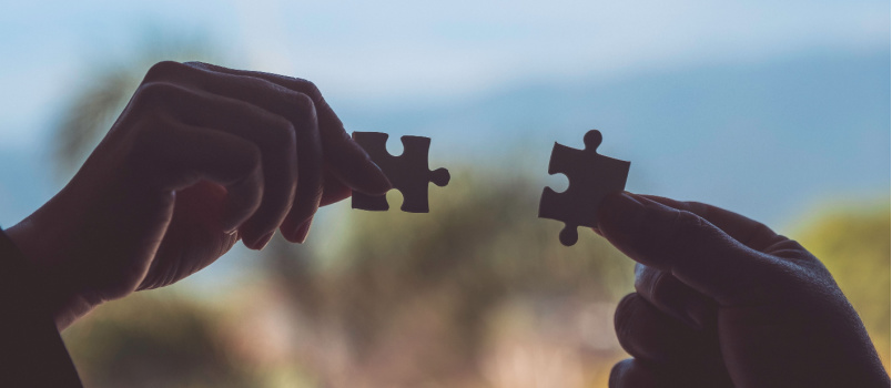 Two hand holding jigsaw
