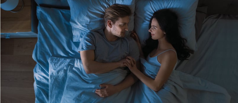 Young couple sleeping together on bed