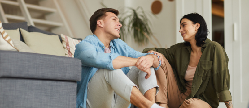 Couple sitting on floor talking to each other