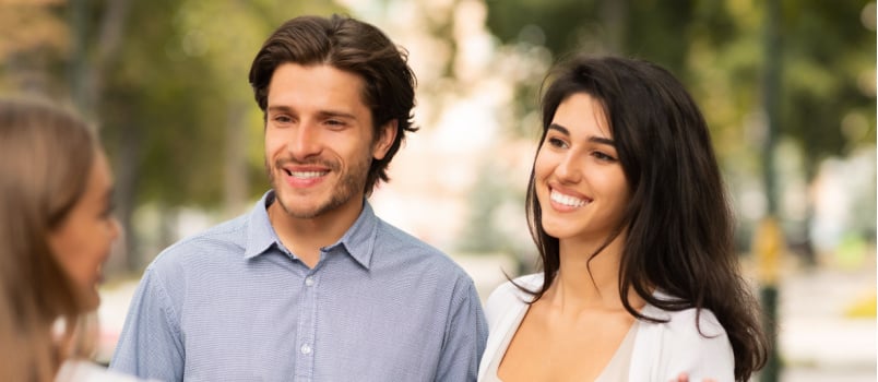 Happy couple talking to friend
