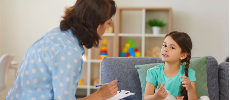 Supportive psychologist having session with kid