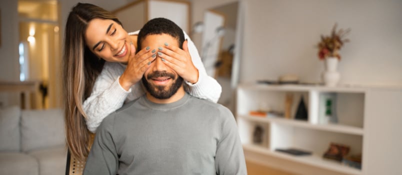 Woman closing man eyes