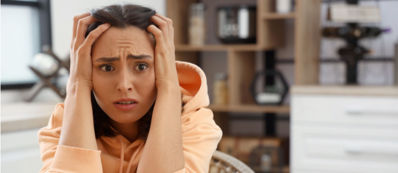 Afraid woman sitting on table