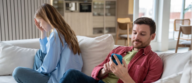 Woman crying turning out man using smartphone