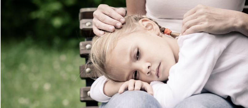 Sad mother and daughter sitting on bench