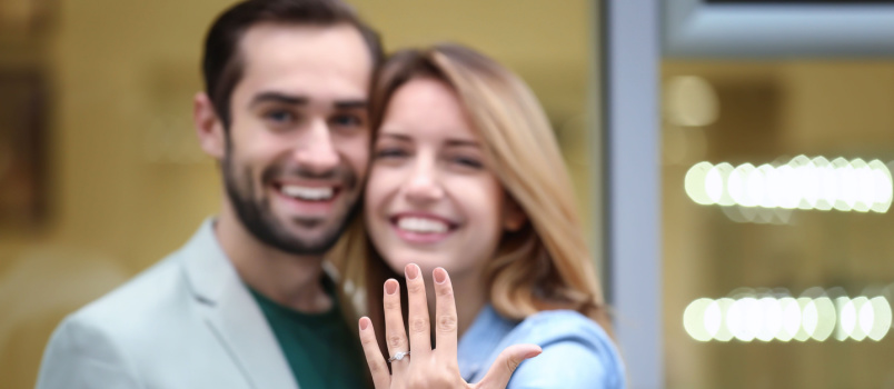 Happy couple woman showing wedding ring