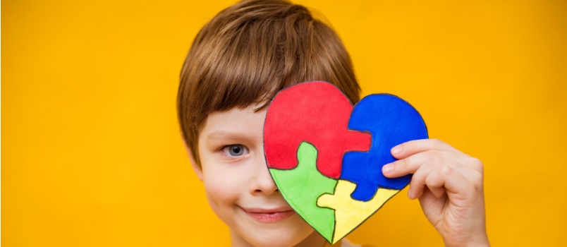 Kid holding heart puzzle