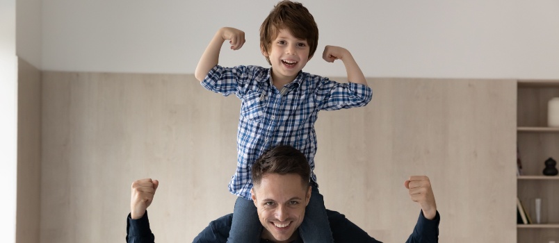 Little boy riding on dad