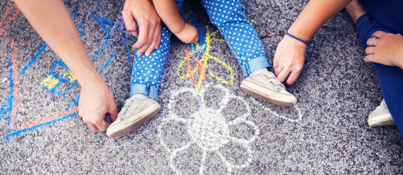 Little girl and her parents drawing on floor
