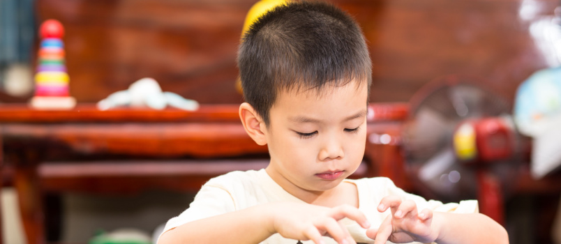Boy trying to using laptop