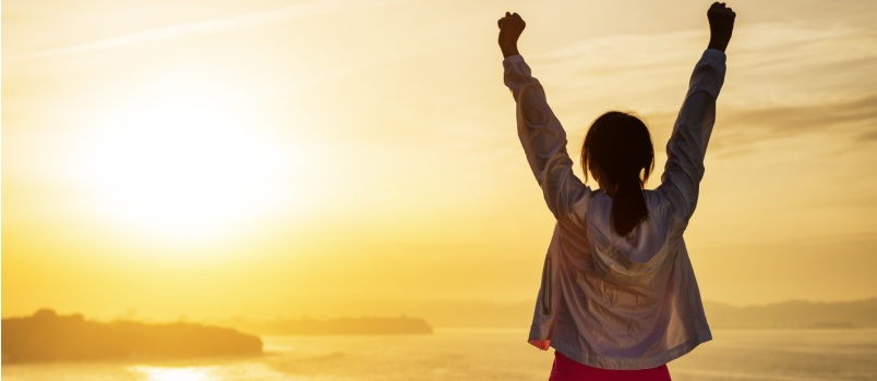 Sporty woman raising her arms