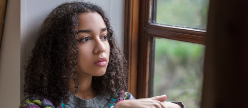 Sad woman sitting beside window