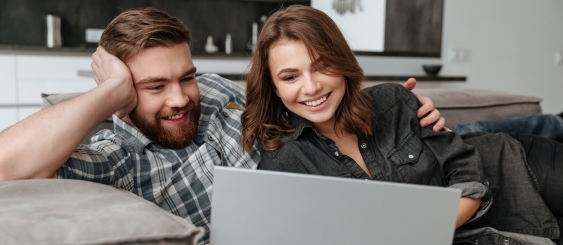 Happy couple using laptop