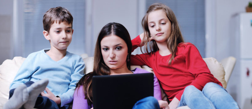 Children using laptop with mother