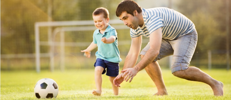 Father and son playing football together