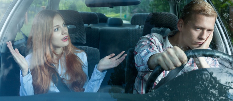 Bored man listening to woman sitting in car