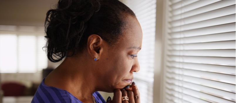 Older woman praying looking out