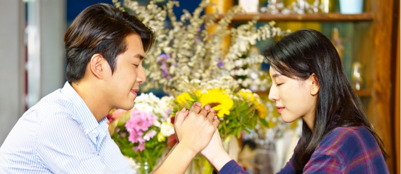 Young couple sitting holding each other hands