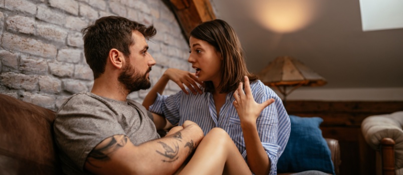 Yong couple talking sitting on bed