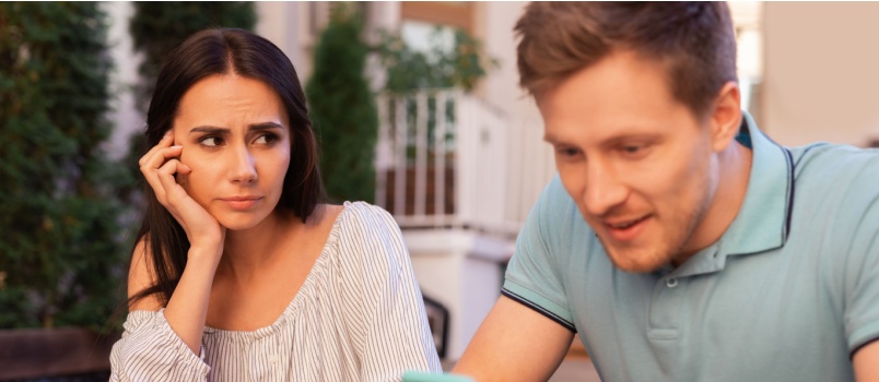 Man busy in phone while woman is looking at him