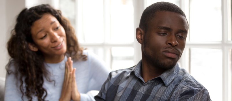 Woman apologizing to man