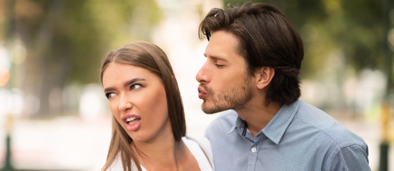Woman rejecting kissing man
