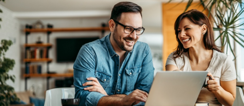 Happy couple using laptop