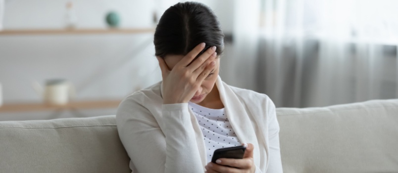 Stressed woman holding phone