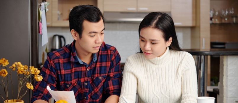 Asian couple reviewing the bills