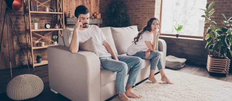 Couple sitting apart on couch
