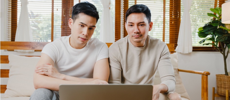 Gay couple watching something on laptop