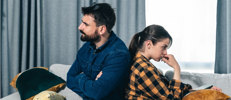 Young couple arguing sitting on couch