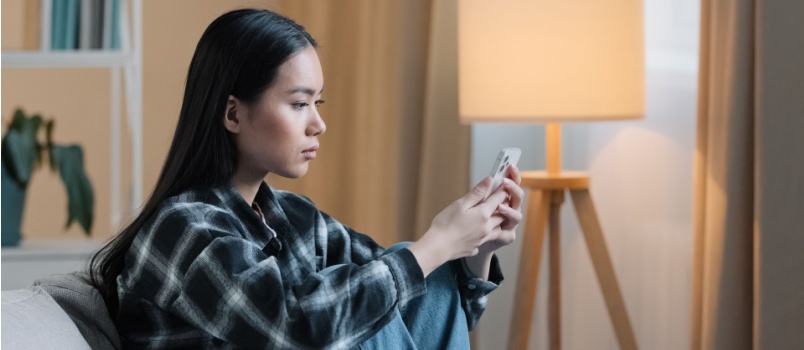 Bored young woman using smartphone