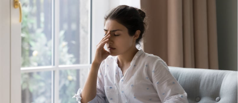 Sad woman sitting beside the window