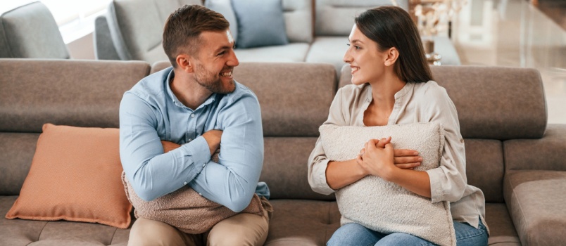 Couple sitting on couch talking to each other