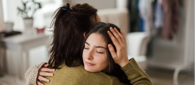Mother hugging daughter