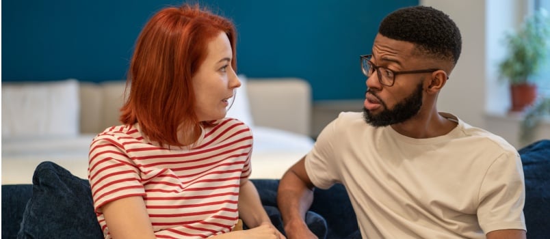 Couple sitting on couch talking to each other