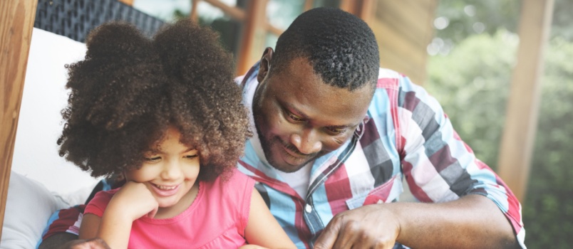 Father and daughter reading book together
