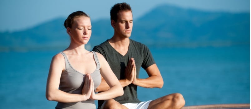 Attractive young man and woman doing yoga