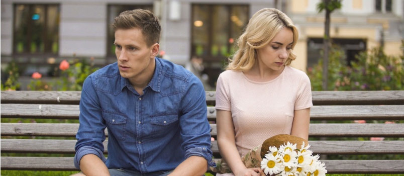 Unhappy couple sitting after fight